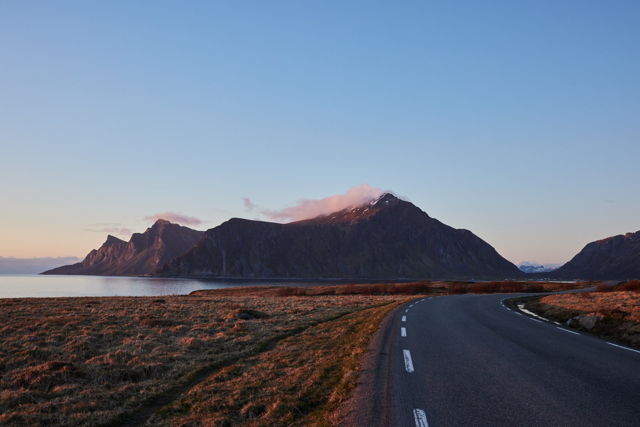 Fjell og landevei i Lofoten ved solnedgang